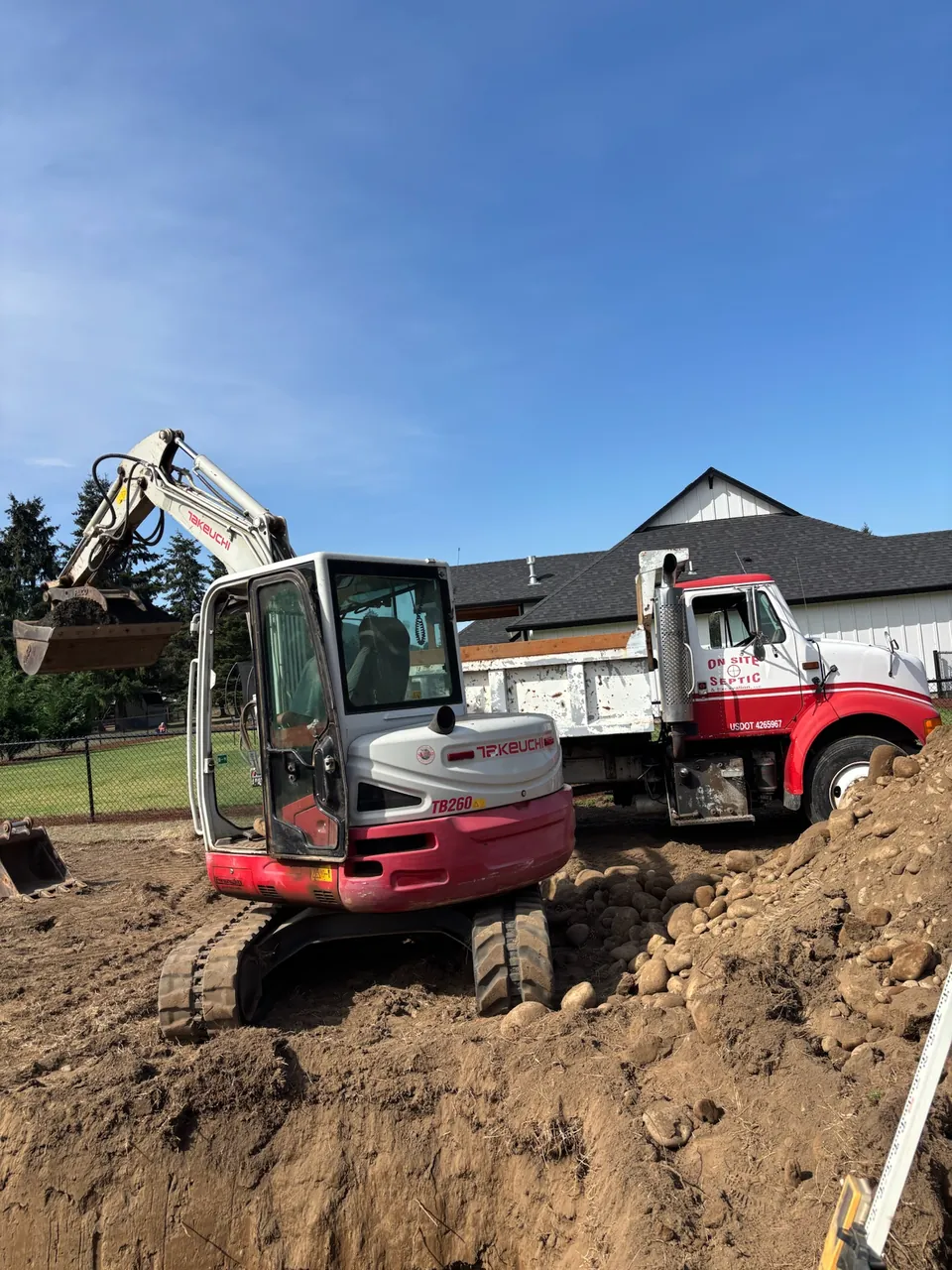 Takeuchi excavator beside the On-Site Septic and Excavation dump truck